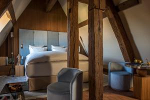 a bedroom with a bed and a chair and a table at Cour des Vosges in Paris
