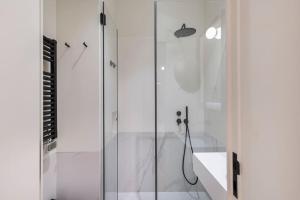 a bathroom with a shower with a glass door at Secret Garden by Innkeeper in Lisbon