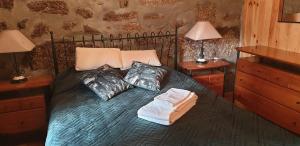 a bedroom with a bed with two pillows and two lamps at Casa Frade in Sabugueiro