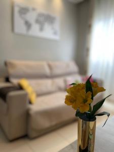 un jarrón con flores amarillas en la sala de estar en Massagua House, en Caraguatatuba