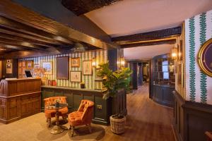 a room with a table and chairs and a desk at Salisbury Arms Hotel in Hertford