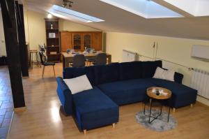 sala de estar con sofá azul y mesa en ApartEłk - apartament w Ełku, en Ełk