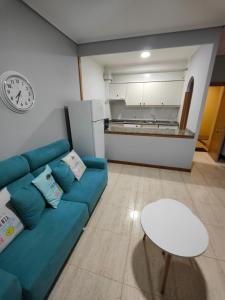 a living room with a blue couch and a table at Apartamento Samil Primera Línea de Playa 2F in Vigo