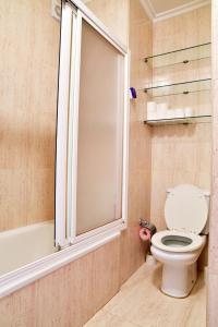 a bathroom with a toilet and a window and a tub at Apartamento Samil Primera Línea de Playa 2F in Vigo