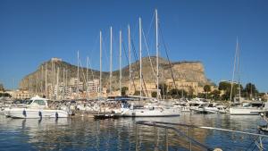 a bunch of boats docked in a harbor with a mountain at Casetta Delia in Palermo