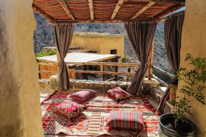 a bed on a balcony with pillows on it at the suwgra-Al-Jabal Al-Akdar in Sūkirah