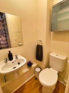 a bathroom with a white toilet and a sink at Centrally Located Loft Apartment in Sheffield