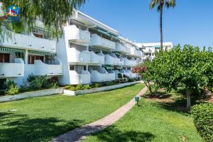 a large white apartment building with a yard at Apartamentos Arcos II Casa Azahar in Alcossebre