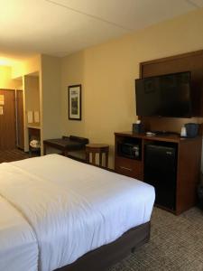 a hotel room with a bed and a flat screen tv at Wingate by Wyndham Grove City in Grove City