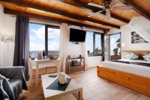 1 dormitorio con 1 cama y sala de estar con ventanas en Torre 5, en Costa Calma