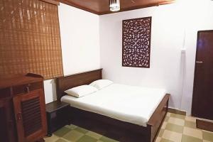 Cette petite chambre dispose d'un lit et d'une photo murale. dans l'établissement The Cottage at Galapitiyaya Estate for 6, à Haputale