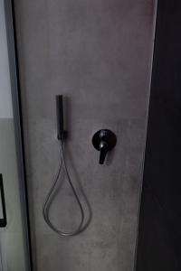 einer Duschkabine mit schwarzem Griff und einer Tür in der Unterkunft Eugenio suite Lecce in Lecce