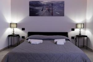 ein Schlafzimmer mit einem Bett mit zwei Kissen darauf in der Unterkunft Eugenio suite Lecce in Lecce