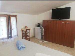 1 dormitorio con 1 cama y TV de pantalla plana en Tra montagna e mare, en Calangianus