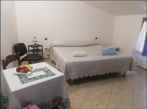 Un dormitorio con 2 camas y una mesa con un plato de fruta. en Tra montagna e mare, en Calangianus