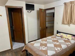 a bedroom with a bed and a tv on the wall at 9 de octubre in Oruro