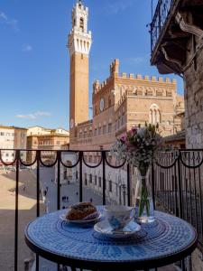 un tavolo con due piatti di cibo e un vaso di fiori di Residenza d'Epoca " Il Campo" by FrancigenaApartments a Siena