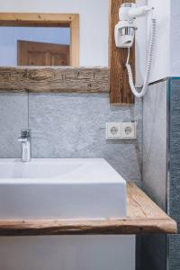łazienka z białą umywalką i lustrem w obiekcie Appartement Adamhof Spielberg Leogang w mieście Leogang