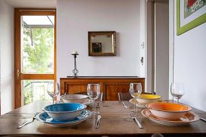 una mesa de madera con tazones y copas de vino. en Il Gelsomino - Terrace Country House, en Pisano