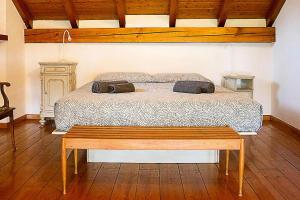 - une chambre avec un lit et un banc en bois dans l'établissement Il Gelsomino - Terrace Country House, à Pisano
