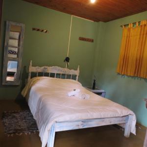 Pousada Alquimia في أيوريوكا: غرفة نوم بسرير في غرفة بجدران خضراء