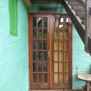 uma porta de madeira para uma casa com uma escada em Pousada Alquimia em Aiuruoca