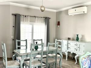 a dining room with a table and chairs and a window at Luxorious villa with a pool near the laguna in Dahab