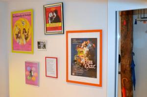 a wall with posters and pictures on it at Un jour d'été à Albi - Centre Unesco - 200 m Cathédrale - Parking - Animaux acceptés in Albi