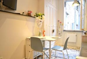 a kitchen with a table and two chairs and a window at Un jour d'été à Albi - Centre Unesco - 200 m Cathédrale - Parking - Animaux acceptés in Albi +34 photos