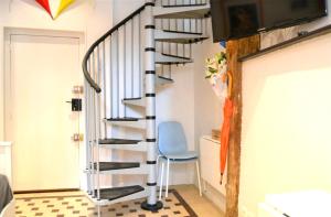 a spiral staircase in a room with a blue chair at Un jour d'été à Albi, Mon-Appart Hotel-ALBI in Albi