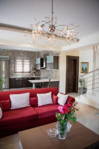 a living room with a red couch and a kitchen at Villa Valentina in Kala Nera