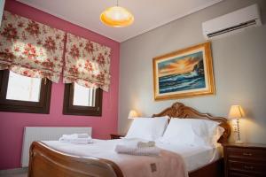a bedroom with a bed with pink walls and windows at Villa Valentina in Kala Nera