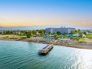 a pier in the water next to a beach at Le Monde Beach Resort & Spa in İzmir