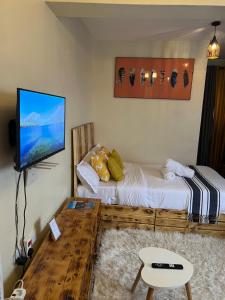 Habitación con cama y TV de pantalla plana. en Ruby Modern Homes Studio-Imara Daima,Behind Imaara Mall-JKIA-Horizon, en Nairobi