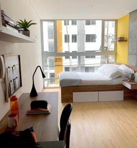 a bedroom with a bed and a large window at Ulivin Apartaestudios Manizales in Manizales