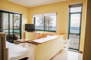 1 dormitorio con 1 cama, TV y ventanas en Apartamento Samil Primera Línea de Playa 2H, en Vigo
