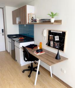 a kitchen with a table and a desk with a chair at Ulivin Apartaestudios Manizales in Manizales