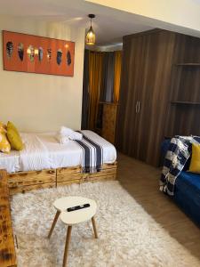 a bedroom with a bed and a table in it at Ruby Modern Homes Studio-Imara Daima,Behind Imaara Mall-JKIA-Horizon in Nairobi