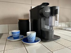 eine Kaffeemaschine und zwei Tassen auf der Theke in der Unterkunft La casa di Chicca in Noventa Padovana