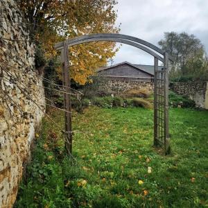 an open gate in a field next to a stone wall at Havre de paix à 10min de Disney in Bussy-Saint-Georges