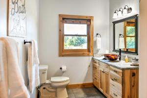 uma casa de banho com um WC, um lavatório e uma janela em Columbia Falls Apt about 17 Mi to Whitefish Resort! em Columbia Falls