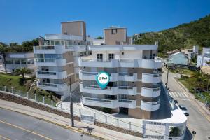 un gran edificio de apartamentos con un círculo azul. en Apartamento para família em Quatro Ilhas - SC, en Bombinhas