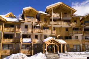 ein großes Apartmenthaus mit Schnee davor in der Unterkunft Centre station 1800 - 2 Chambres - Vue panoramique in Les Orres