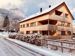 ein Haus im Schnee mit einem Zaun in der Unterkunft hus56 in Mellau