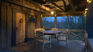 a wooden deck with a table and chairs on it at Dzirnavkalns in Cesvaine