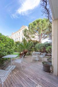 a patio with chairs and tables and a building at Paradise Cannes Center with Pool and Park VILLA LE LYS in Cannes
