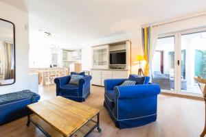 een woonkamer met twee blauwe stoelen en een tafel bij Paradise Cannes Center with Pool and Park VILLA LE LYS in Cannes