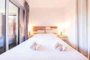 een slaapkamer met een groot wit bed met twee kussens bij Paradise Cannes Center with Pool and Park VILLA LE LYS in Cannes +15 foto's