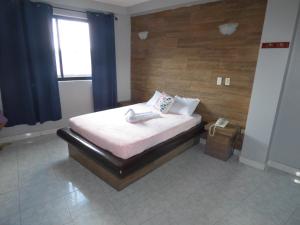 małą sypialnię z łóżkiem z oknem w obiekcie ART CASCO The Hotel w Panamie