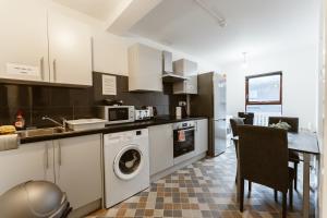 una cucina con lavandino e lavatrice di Whitechapel en-suite beds to stay a Londra